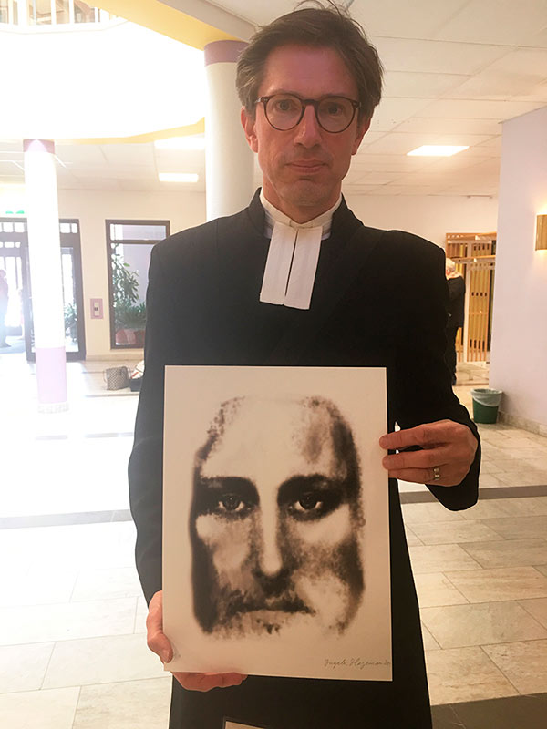 Kyrkoherede med svartvit kristusbild